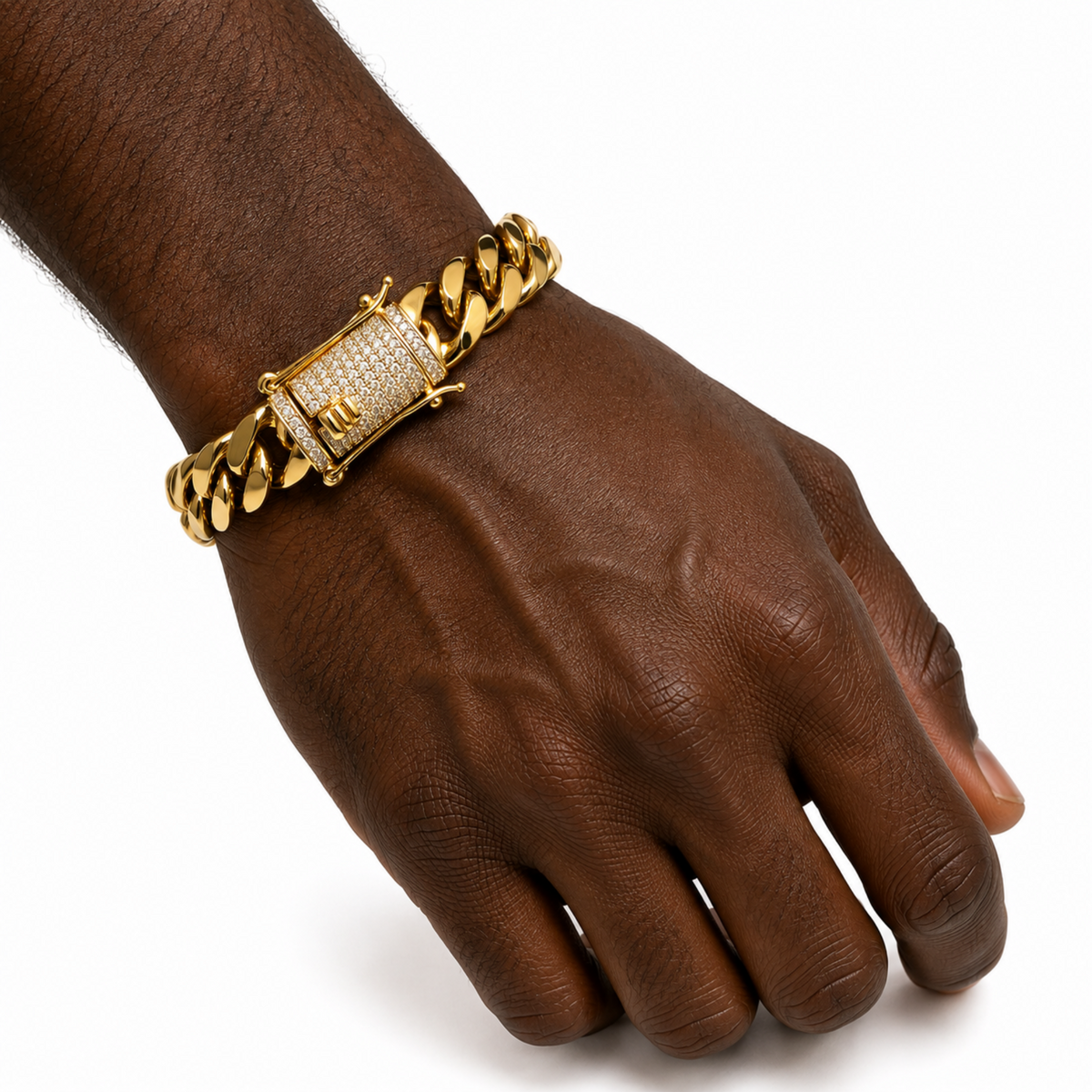 A gold-toned Cuban link chain bracelet with a rectangular clasp paved with clear stones and featuring a small gold 'H' emblem, shown worn on a person's wrist against a white background.