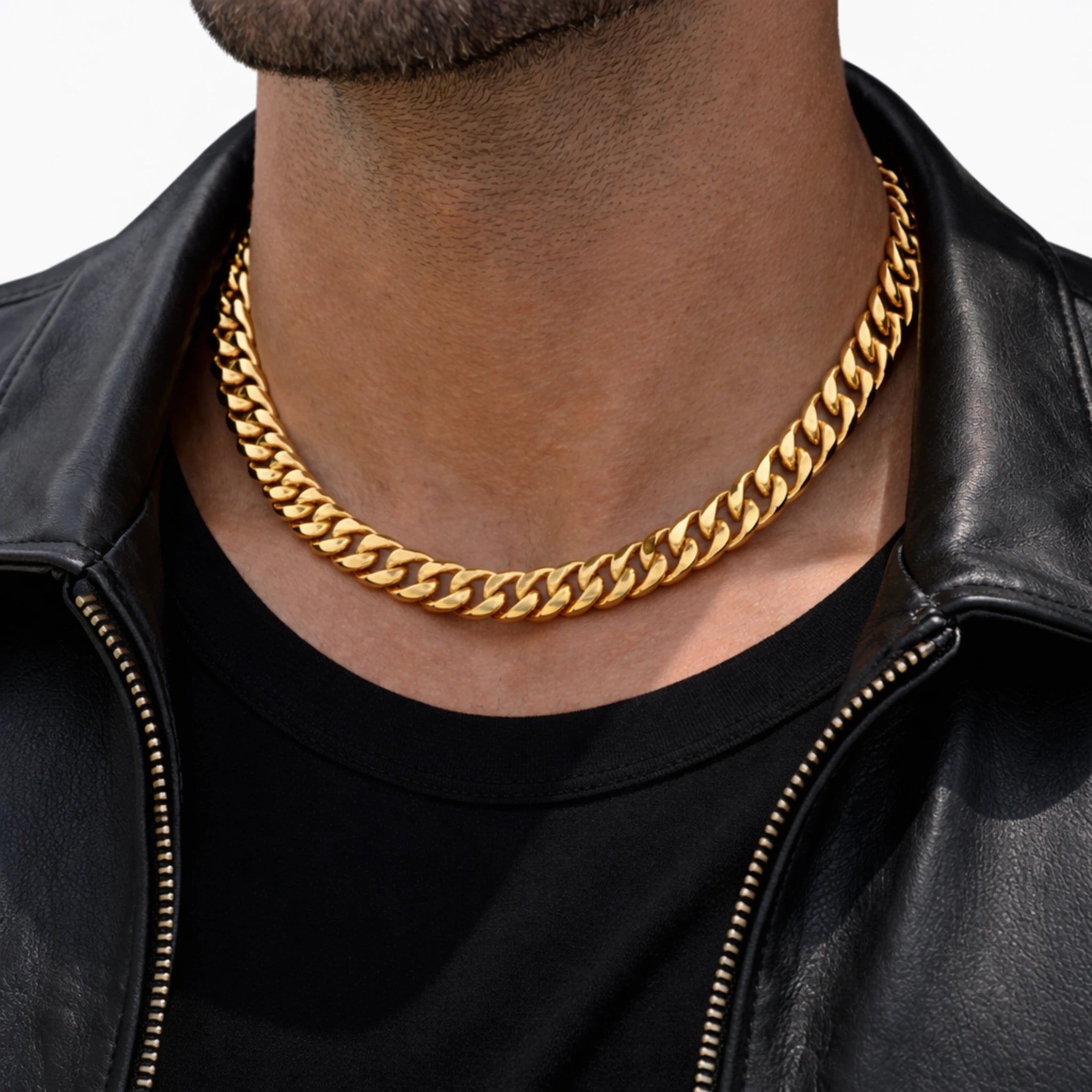 Gold chain necklace worn by a person in a black leather jacket and black shirt.