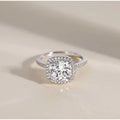 Diamond ring with a cushion-cut center stone on a beige background