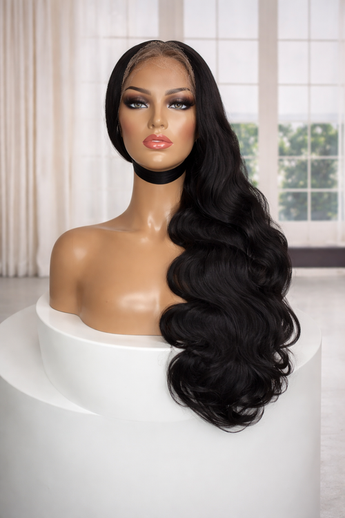 Black wig on a mannequin head with a white background